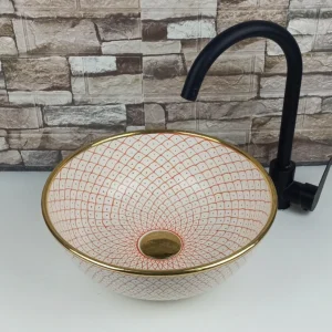 Moroccan ceramic vessel sink with soft pink geometric pattern and gold rim