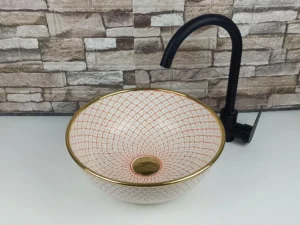 Moroccan ceramic vessel sink with soft pink geometric pattern and gold rim